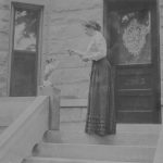 Woman feeding treat to dog on porch